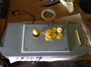 Needed to make a shelf to mount the Playstation 1 Controller. Masking up the buttons ready for painting. 2002