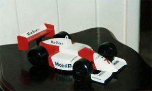 I always wanted a model f1 car. At age 15 I carved this out of 2 pieces of 2x4" Pine Timber and scrap Balsa Wood. Painted with 'Tiny Tins' and a steady hand. Decals were hand drawn on paper and glued on. 1994